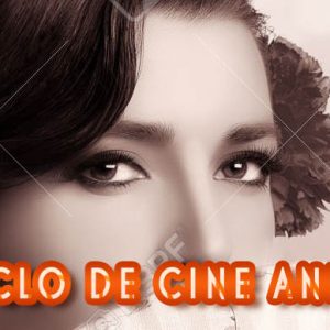 Gypsy girl. Beautiful Andalusian woman with carnation in hair and covering half face with a stylish fan. Spanish beauty. Fine Art portrait in sepia with copy space for text.